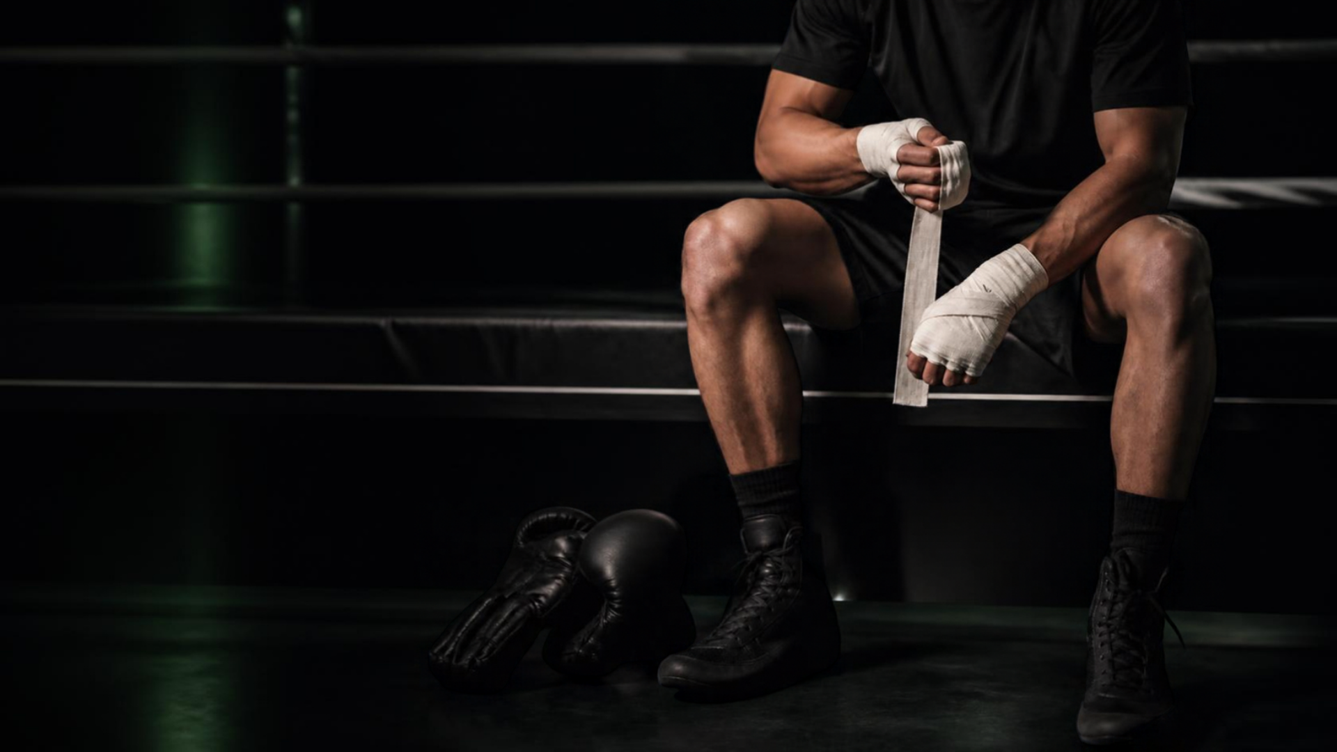 Hands being wrapped beside gloves and boots
